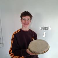 Eine Person mit freundlichem Allerweltsgesicht und einem appetitlich aussehenden Kuchen.
